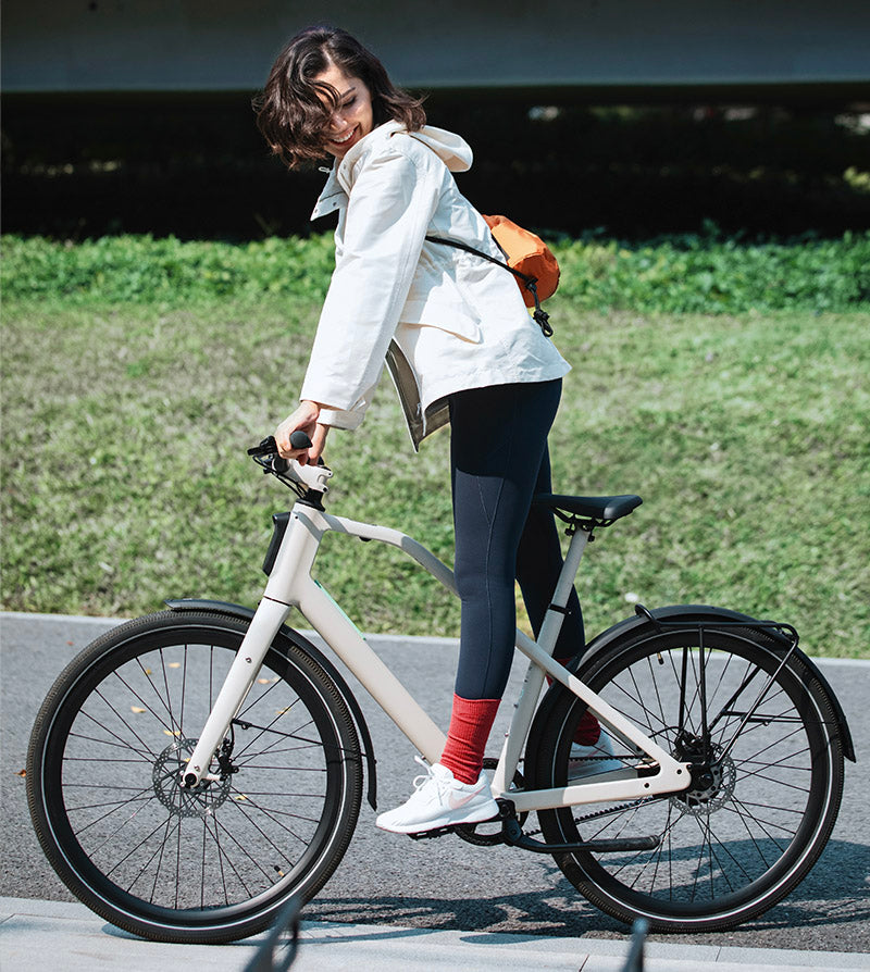 Eine Frau fährt auf einem Damen-E-Bike in aufrechter Position.