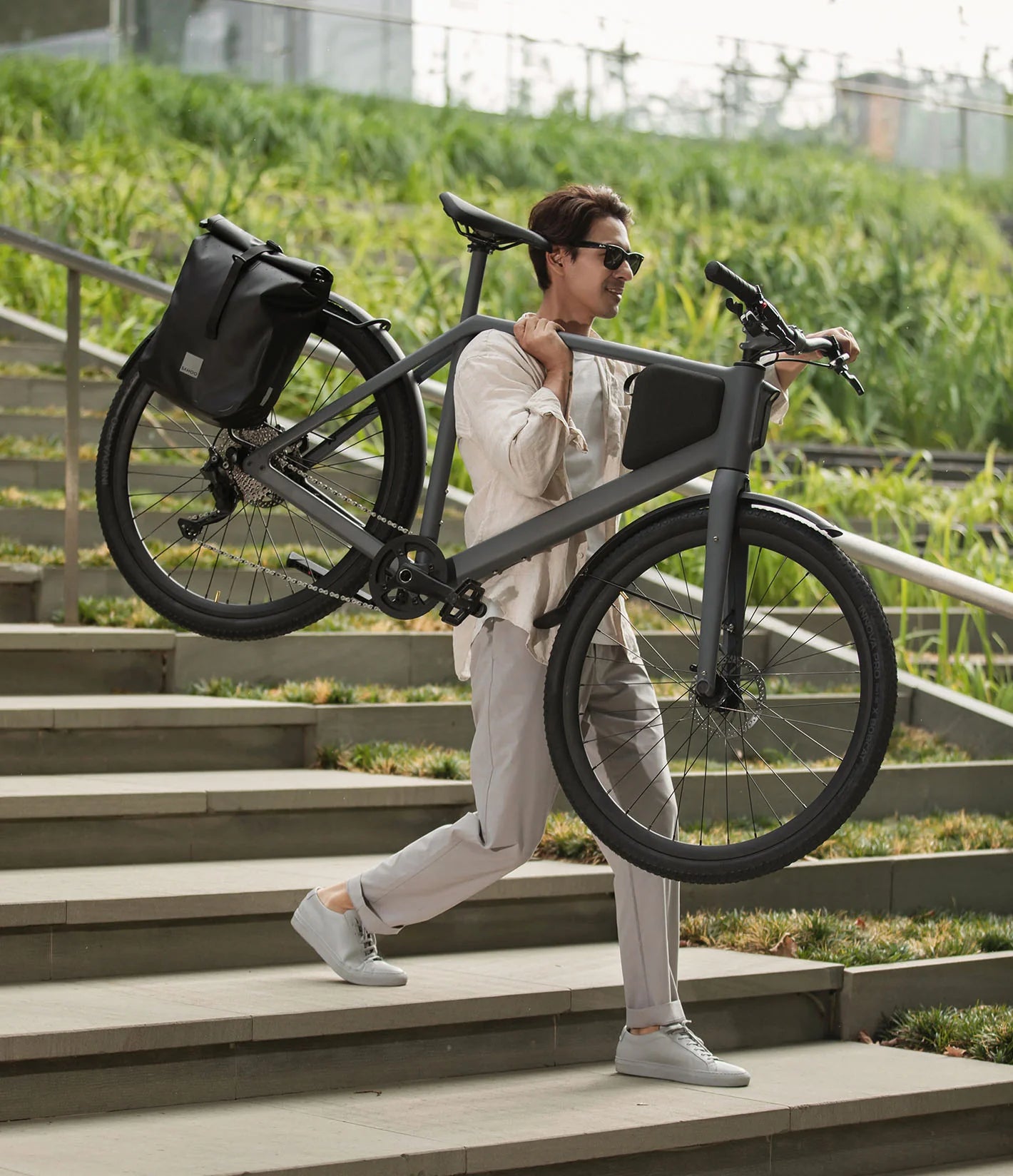 Mann trägt LEMMO Leichtgewicht-E-Bike einhändig die Treppe hinunter
