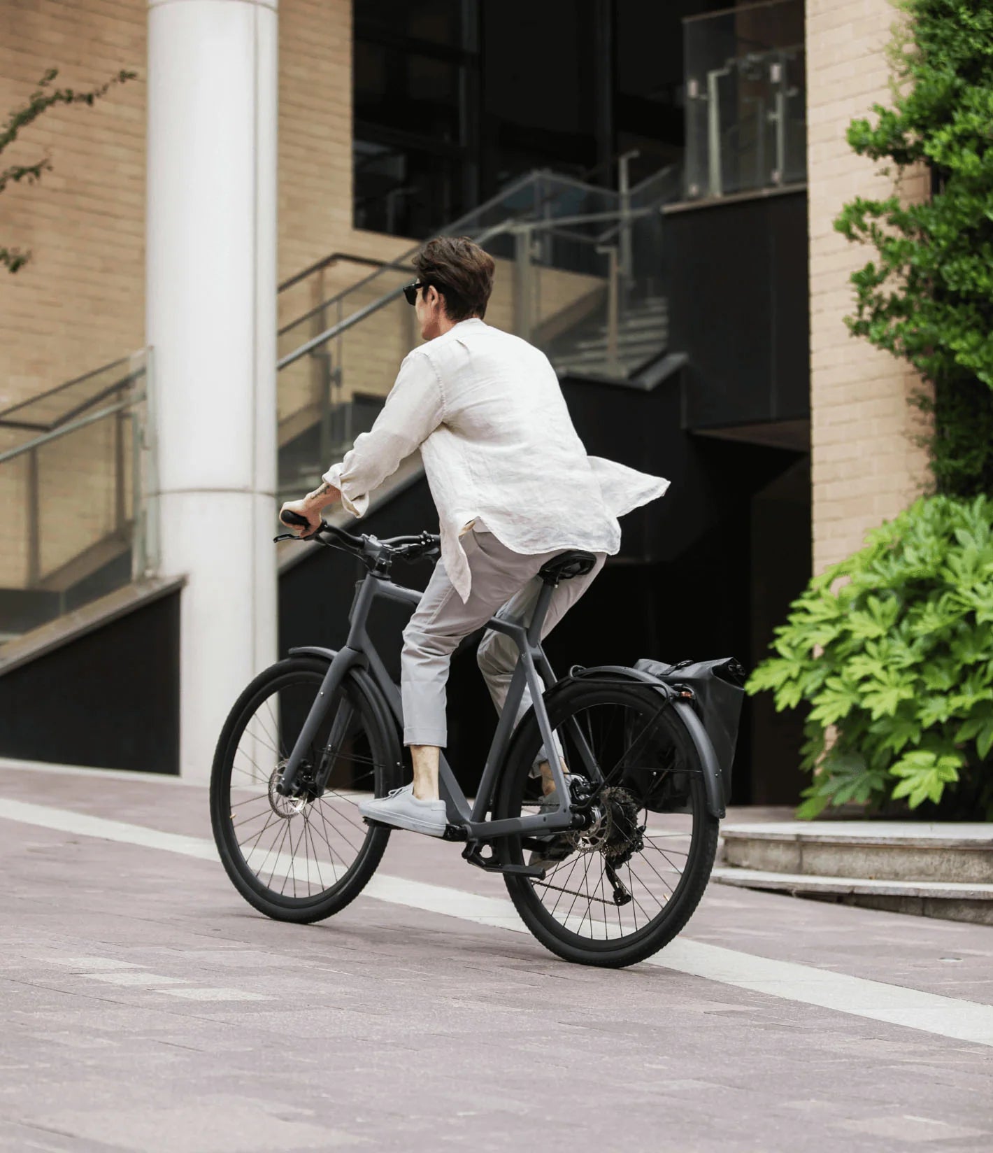 Mann fährt LEMMO urban e-bike mit Gepäckträger.
