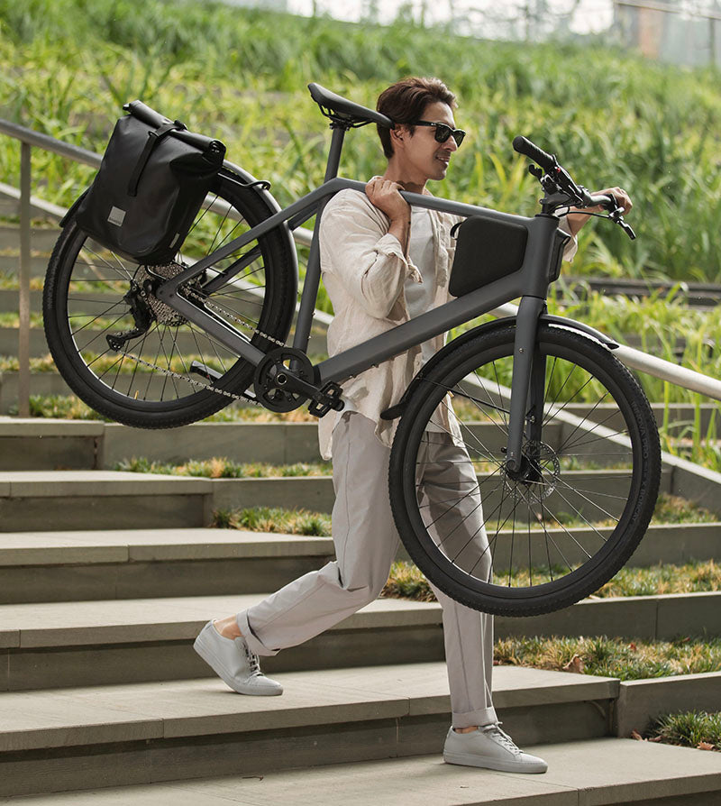 Ein Mann trägt ein leichtes LEMMO E-Bike einhändig die Treppe hinunter