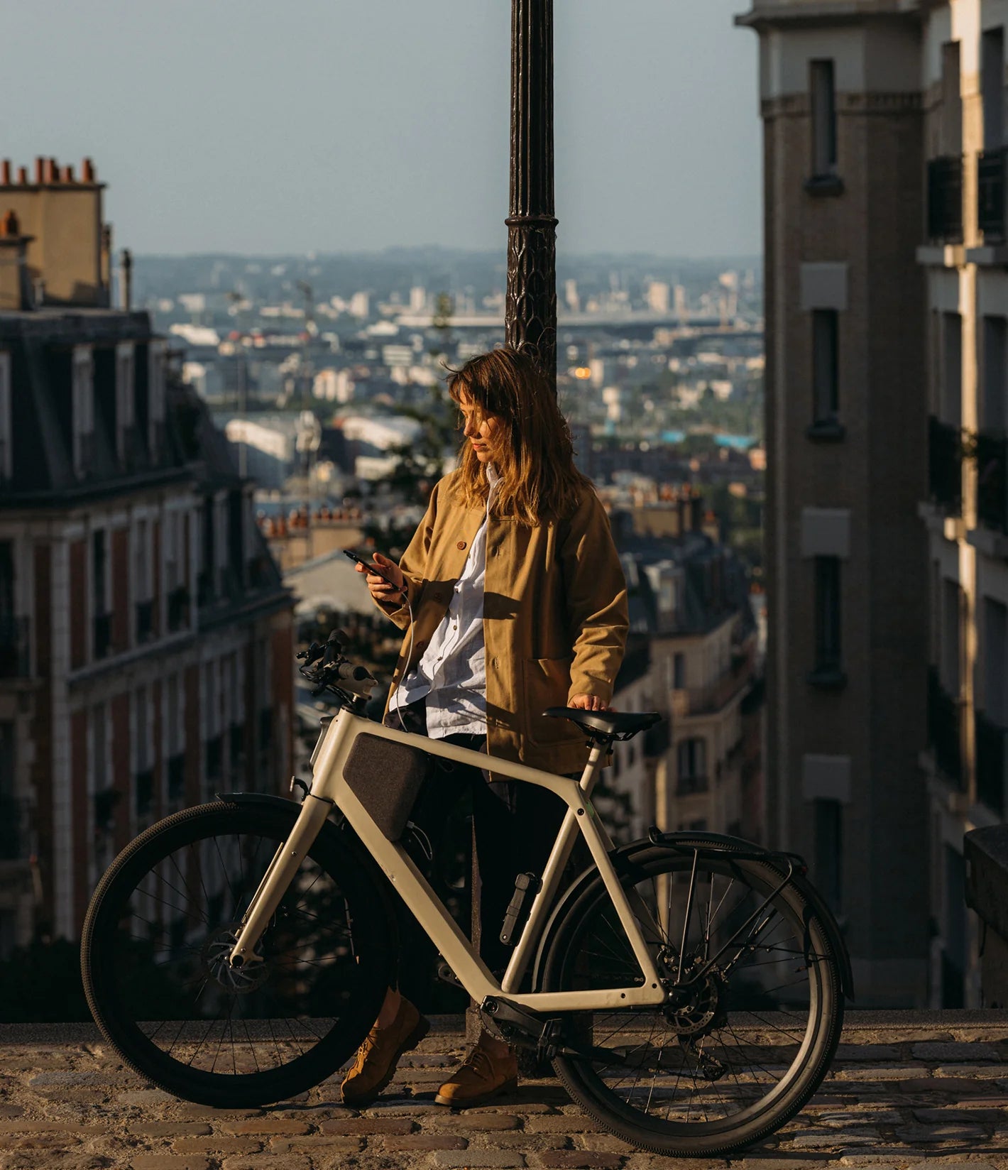 Frau lädt Handy mit LEMMO E-Bike Akku entnehmbar